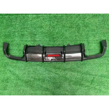 Carbon fiber rear diffuser on textured background - side view