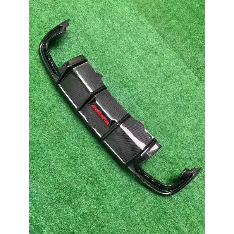 Carbon fiber rear diffuser on textured background - angled view