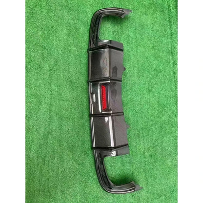 Carbon fiber rear diffuser on textured background - vertical view