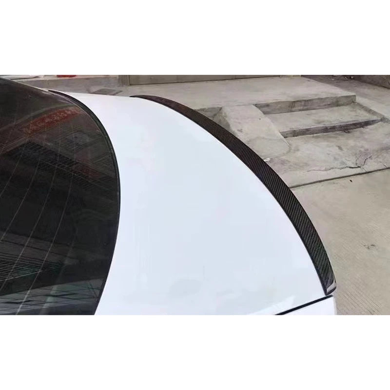 Carbon fiber lip spoiler installed on white Audi A6 - close-up