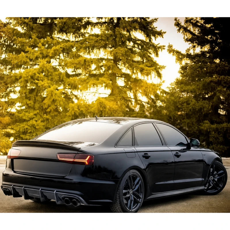 Carbon fiber ducktail spoiler installed on black Audi A6 - rear three-quarter view