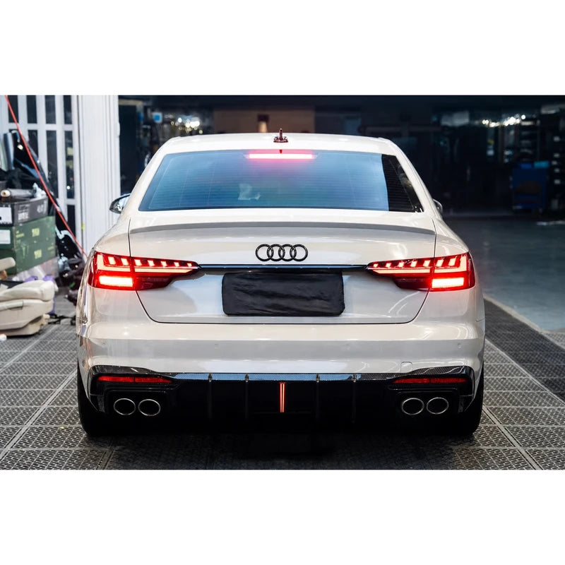 Carbon fiber rear diffuser installed on white Audi A4 - garage rear view